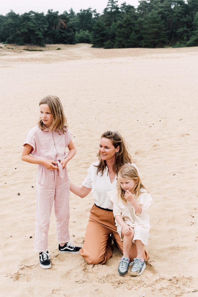 Moeder en haar twee dochters op de zandvlakte op de Veluwe tijdens een fotoshoot van familiefotograaf Studio Kijk